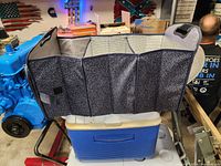 View of expandable grocery carrier from side showing three separate foldable compartments with insulated lining and handles.