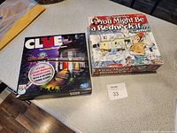 Top-down view of two board game boxes on a countertop: Clue and You Might Be a Redneck If... Game.