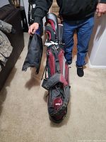 Person holding golf bag with clubs inside, showing size and condition of the bag and clubs.