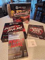 Photo showing all four items: Whodonut? puzzle box, Death at the Dive Bar game box, Criminal Mind Puzzles book, and Perfect Score novel.