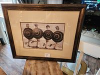 Full view of one framed vintage photo showing four ladies in swim suits with parasols on beach