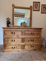Front view of pine wood dresser with mirror showing six drawers with metal handles and Southwestern wood stain finish.