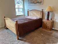 Overall side view of pine bed frame with nightstand and lamp