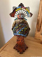 Front view of lamp showing Kachina-style figure and stained glass orb shade