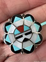 Front view held in hand showing geometric inlay pattern and scalloped bezel