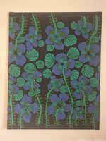 Front view of framed textile piece showing blue and green botanical floral pattern on black background.