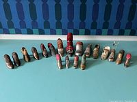 Full lot of approximately 20 shoe pin cushions arranged in a row, showing size and style variety.