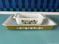 Two Pyrex baking dishes stacked showing the floral pattern on the side and top view of the pans