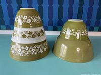 Side view of the five Pyrex mixing bowls stacked in two groups showing the Spring Blossom pattern and the one solid green bowl