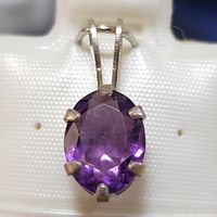 Front close-up of the oval amethyst in sterling silver pendant showcasing the faceted stone and prong setting.
