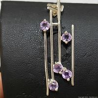 Front view of the sterling silver pendant with five round light purple amethyst stones on linear silver bars.