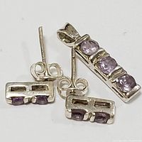 Pendant and earrings displayed on white background showing rectangular sterling silver settings with multiple round amethyst stones.