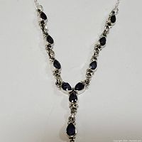 Front view of the sterling silver necklace with multiple pear-shaped iolite stones showing the Y-shaped pendant design.