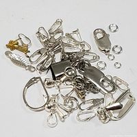Sterling silver mixed jewelry findings on white background showing hooks, clasps, jump rings, and more.