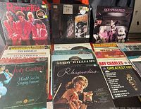 Overview of 23 vinyl record albums showing covers for The Romantics, Waylon Jennings, Rick Springfield, Judy Garland, Ray Charles and others