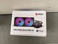 Front of box showing MSI MAG CoreLiquid 240R V2 RGB liquid cooler with Mystic Light branding and dual RGB fans illustration.