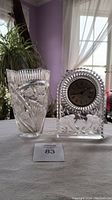 Front view of the Anna Hutte leaded crystal vase and Princess House desktop clock side by side on a table, showing detailed cut patterns and clock face.