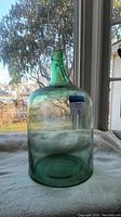 Front view of large green glass jug showing its size and color.