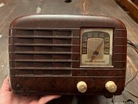 Front view of antique GE radio showing dial, two control knobs, and walnut mottled bakelite cabinet.