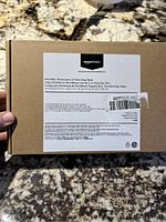 Outer label on the brown Amazon Basics box showing product details including size, color as black, microfiber material, and pack of two pillowcases.