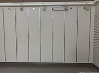 Long metal wall strips installed vertically on a white wall, showing the slot pattern and mounting brackets in place.