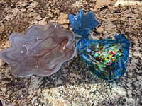 Three Murano glass bowls arranged on a granite surface showing all items together.