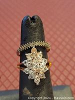 Front view of two rings on display stand showing rhinestone cluster and beaded textured band