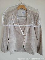 Front view of the Armani Collezioni jacket hung on a wooden hanger covered with a clear garment bag, showing fabric texture and overall condition