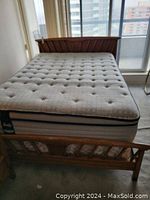 Full view of the wooden double bed frame with mattress for scale. Mattress is not included.