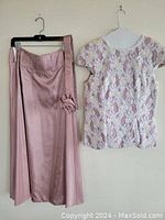 Photo showing the full-length pale pink silk/satin skirt with a flower applique at the waistband, and the matching embellished top with lace and sequin detailing.