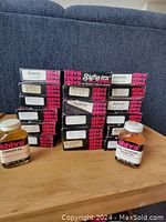 Boxes of Signa-tex and Shiva acrylic paint tubes stacked on a wooden surface with two bottles of oil in front.