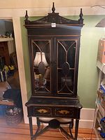 Frontal view of entire black floral hutch including capitals