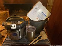 Full view of all included items on display: Instant Pot Duo Plus, tall Calphalon pot (without lid), vacuum coffee canister, two mixing spoons, and manuals.