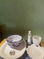 Full lot overview showing milk glass vase, leaf platter, creamy platter, blue and white bowls, miniature Dutch clogs, and small milk glass pot.