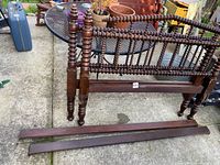 Side view of the bed frame parts showing turned spindle headboard and footboard with two side rails.