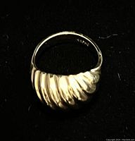 Front view of twisted dome croissant style 14K gold ring showing ridged texture and polished surface.