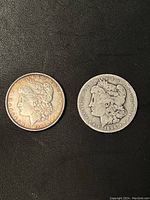 Two Morgan silver dollars showing obverse sides, dated 1889 and 1896, with visible surface wear and tarnishing.