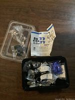 Photo of assorted garden hose cache aerator fittings and accessories in plastic trays with instruction sheet visible.