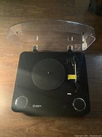 Top view of black Ion Audio Max LP turntable with clear dust cover open showing platter and tonearm.