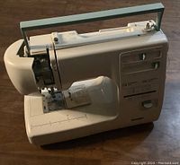 Side view of the Kenmore sewing machine showing overall body, handle, and controls.