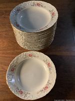 Stack of 15 Spal Porcelamas Portugal floral bowls with one bowl placed in front showing detailed floral and embossed scalloped edges.