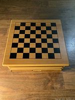 Top view of the wooden case showing a classic chessboard surface with alternating natural and black wood squares.