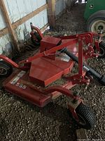 Angled left-front view showing red steel deck, front caster wheels, frame and “555” decal