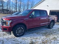 Left side view of red 2018 F-150 showing full truck and alloy wheels