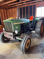 Left-front three-quarter view of tractor showing engine side, front wheel and operator station