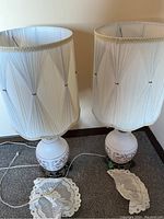 Pair of matching table lamps with frosted glass bases and pleated white fabric shades. Lamps are unpacked and plugged in but untested.