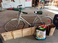 Men's road bicycle, wooden toboggan, and reusable bags in garage setting