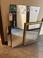 Three wall mirrors together showing the framed mirror, etched floral design on one mirror, and beveled edge mirror.