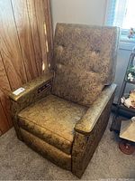 Full view of the retro reclining chair showing patterned upholstery and padded armrests.