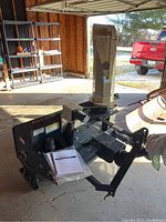 Full view of snow blower attachment showing intake housing, frame and discharge chute with motor